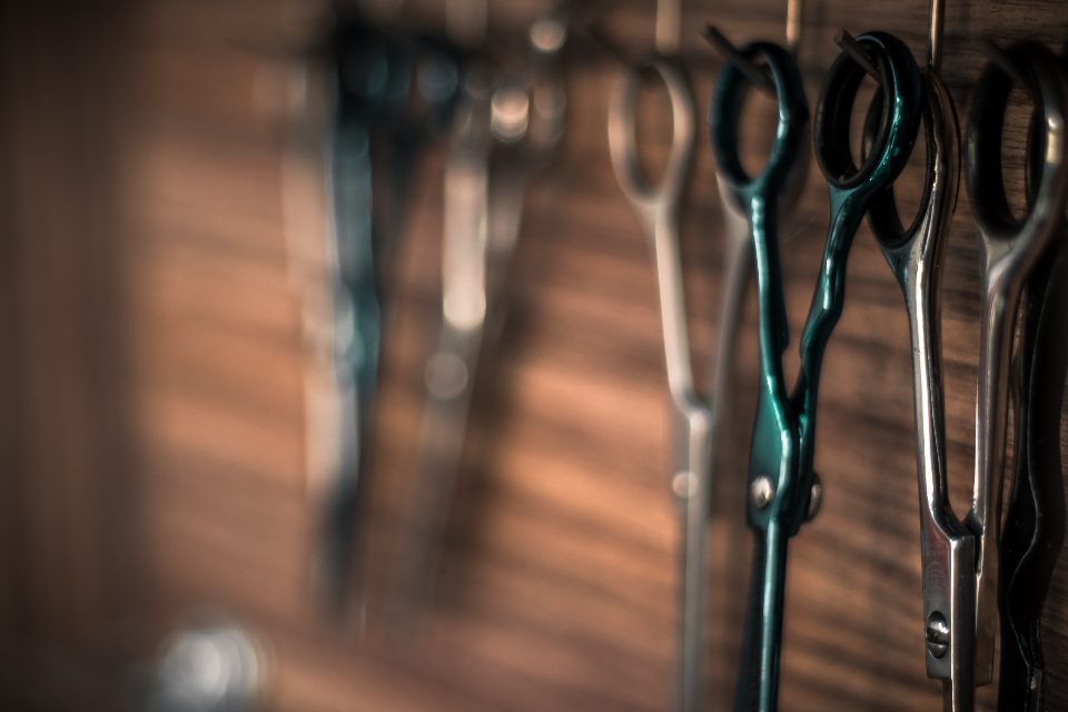 Ciseaux de barbier en gros plan, posés sur le plan de travail du salon Le Cran